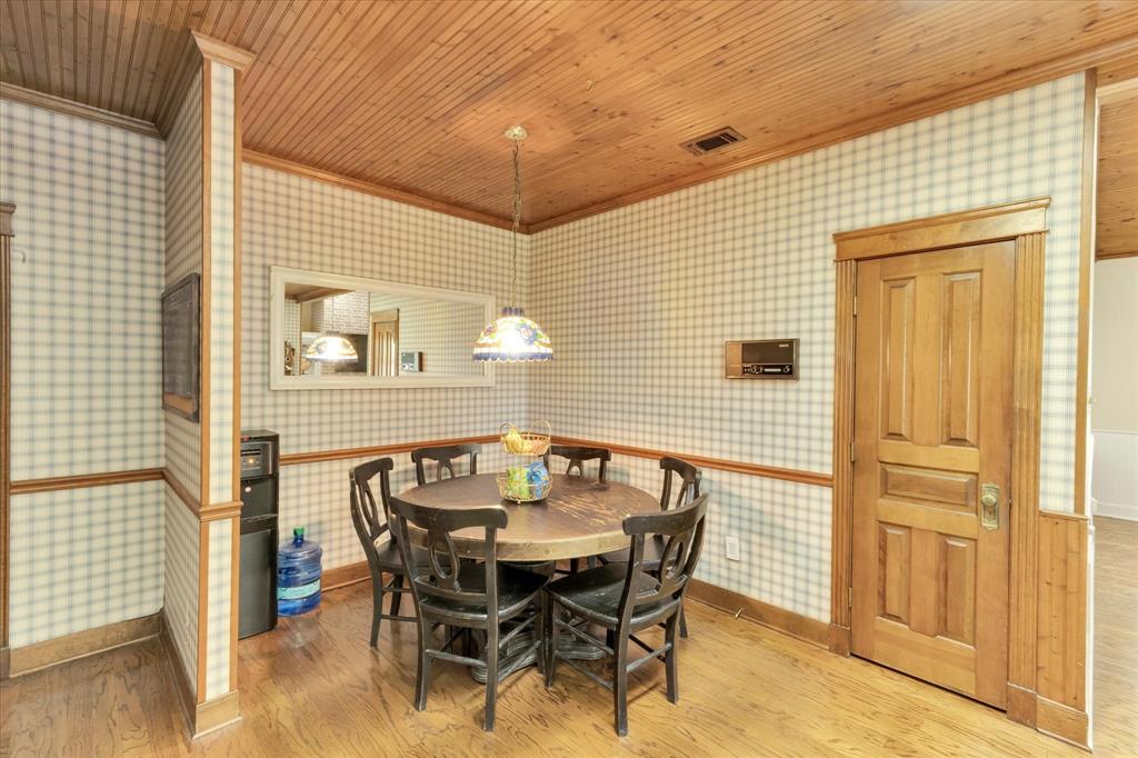2717 Clear Lake Road Weatherford, TX 76087 - Photo 13 of 40 Dining area featuring wood-finish flooring, wood paneling on the ceiling, and plaid pattern wallpaper