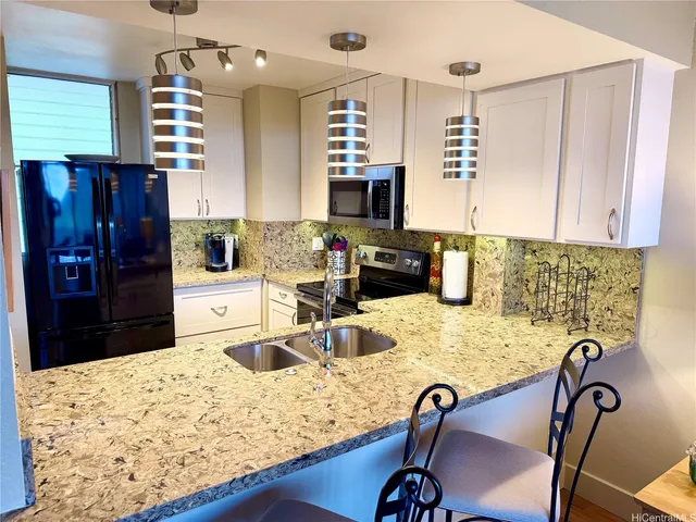 a kitchen with a refrigerator a stove a sink and a dining table