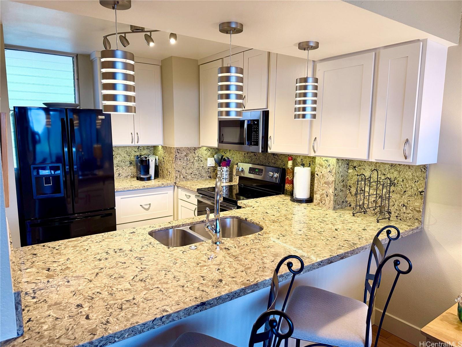 a kitchen with a refrigerator a stove a sink and a dining table