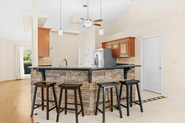a kitchen with granite countertop a refrigerator and a stove top oven