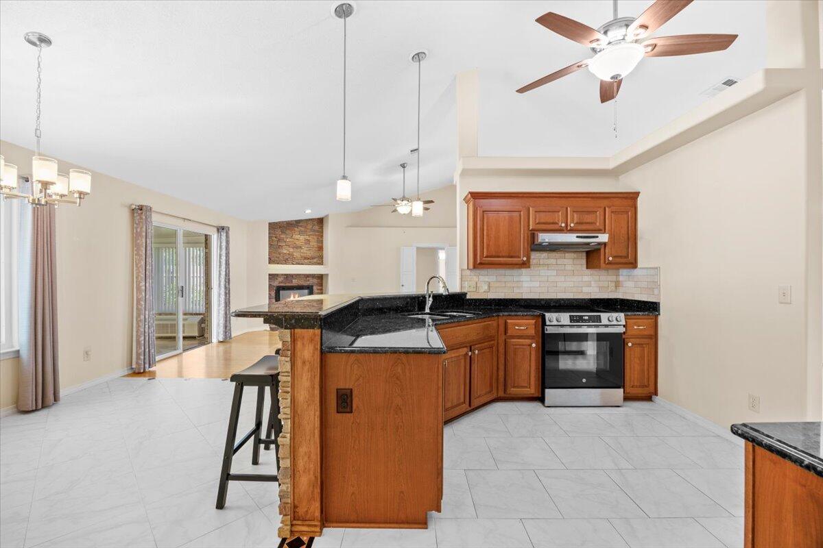 7807 Lola Circle Navarre, FL 32566 - Photo 16 of 45 a kitchen with stainless steel appliances granite countertop a sink a stove and a refrigerator