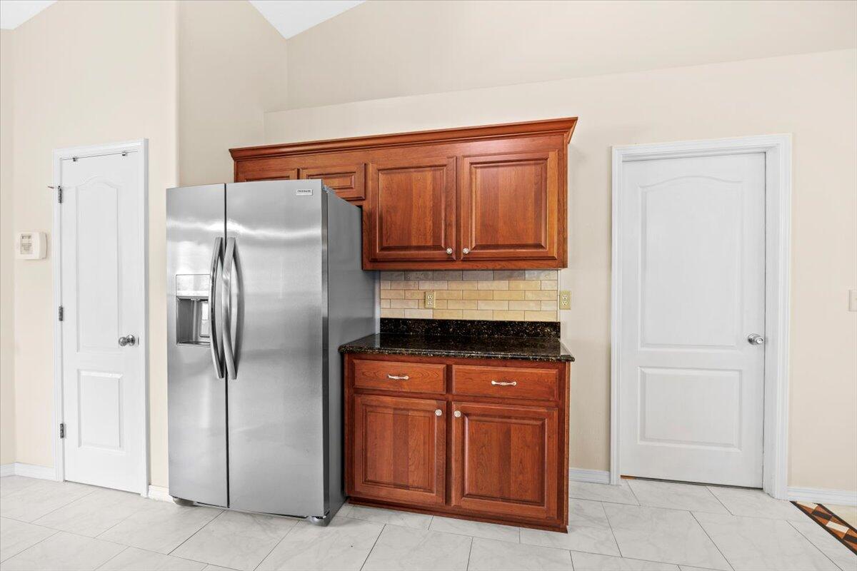 7807 Lola Circle Navarre, FL 32566 - Photo 17 of 45 a kitchen with granite countertop a refrigerator and a stove top oven