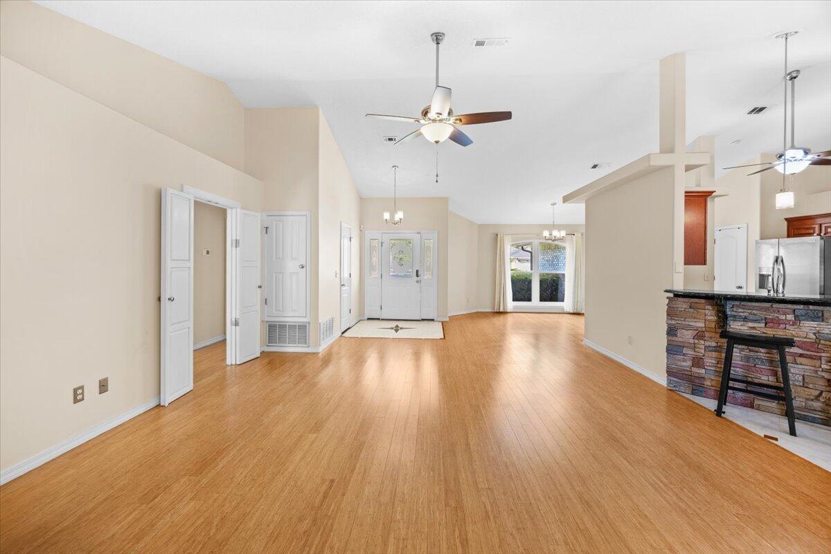 7807 Lola Circle Navarre, FL 32566 - Photo 31 of 45 a view of an empty room and kitchen view with wooden floor