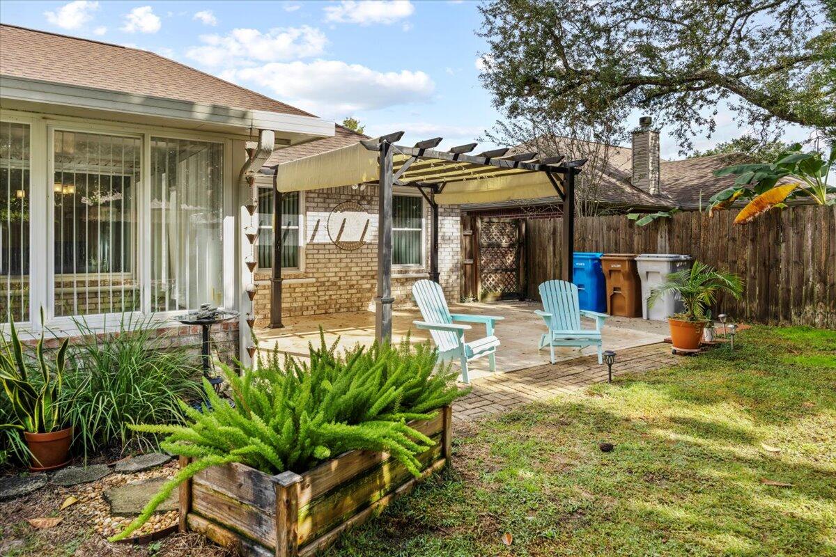 7807 Lola Circle Navarre, FL 32566 - Photo 38 of 45 a view of a building with a garden and plants