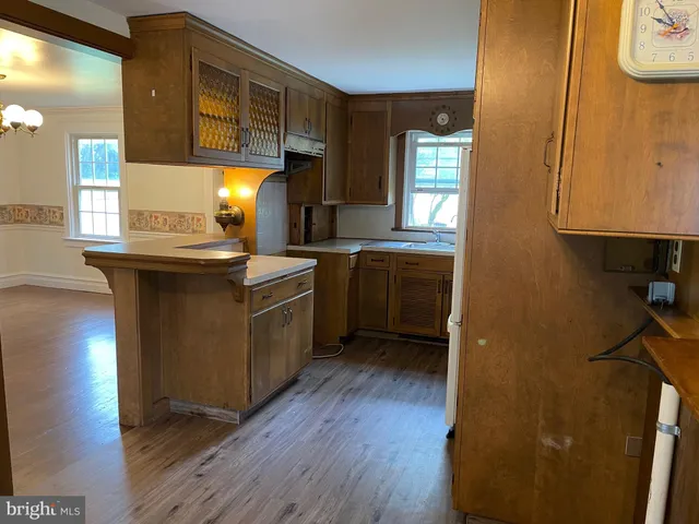 a kitchen with a sink cabinets and wooden floor