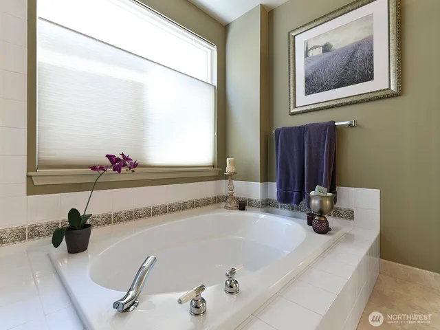 a bathroom with a tub sink and mirror