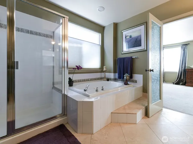 a bathroom with a tub a sink and a mirror
