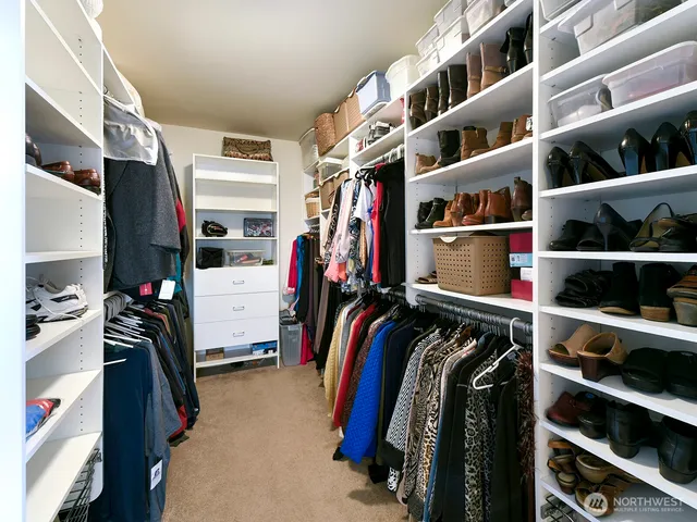 a view of walk in closet with clothes and shoes