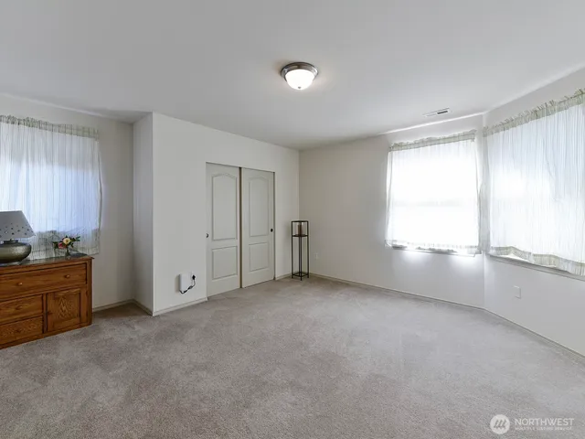a view of an empty room with window and cabinet