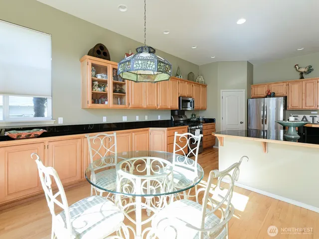 a kitchen with stainless steel appliances granite countertop a sink and a refrigerator