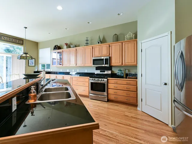 a kitchen with kitchen island a counter top space a sink stainless steel appliances and cabinets