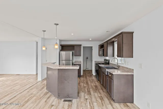 a kitchen with stainless steel appliances granite countertop a stove and a wooden floors