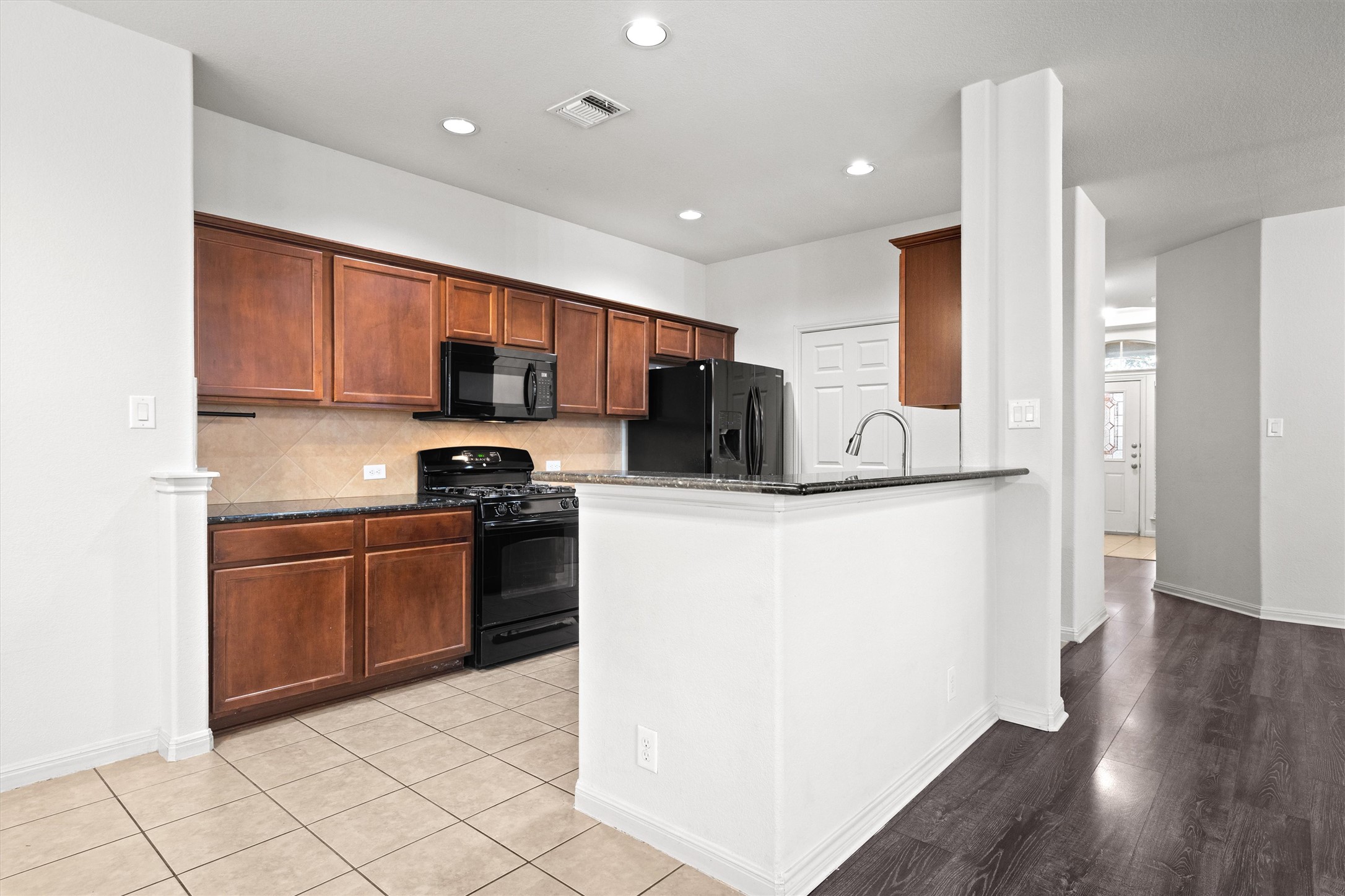 1612 Musket Valley Trail Austin, TX 78754 - Photo 14 of 34 a kitchen with stainless steel appliances granite countertop a refrigerator stove top oven and sink