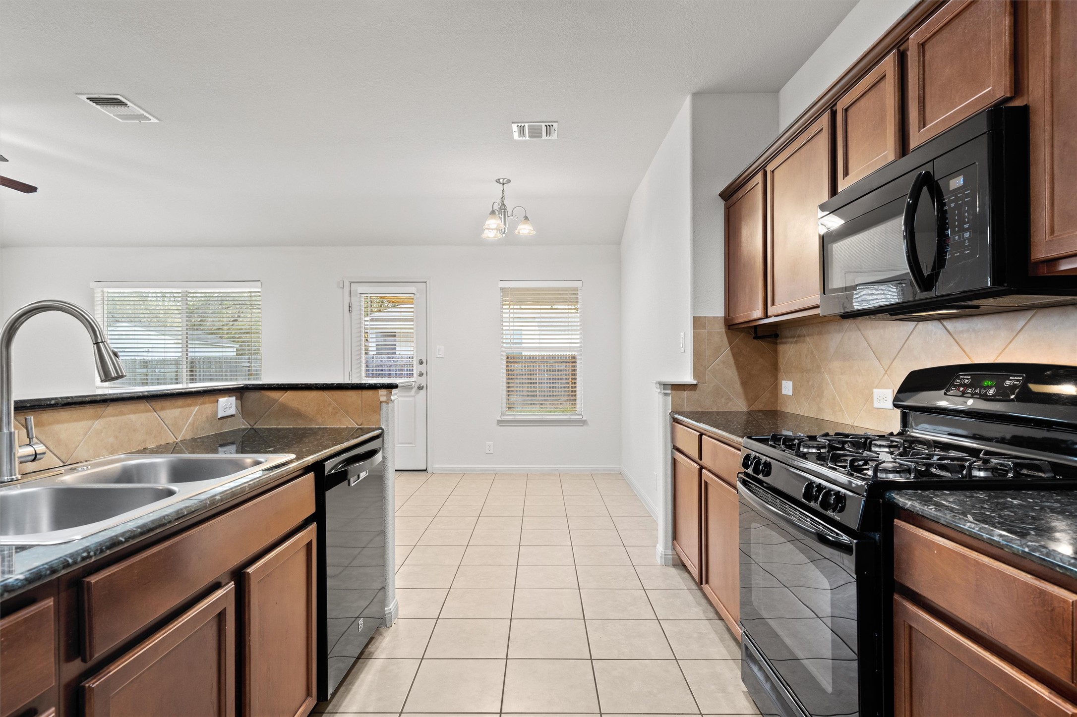 1612 Musket Valley Trail Austin, TX 78754 - Photo 16 of 34 a kitchen with stainless steel appliances granite countertop a sink stove and microwave