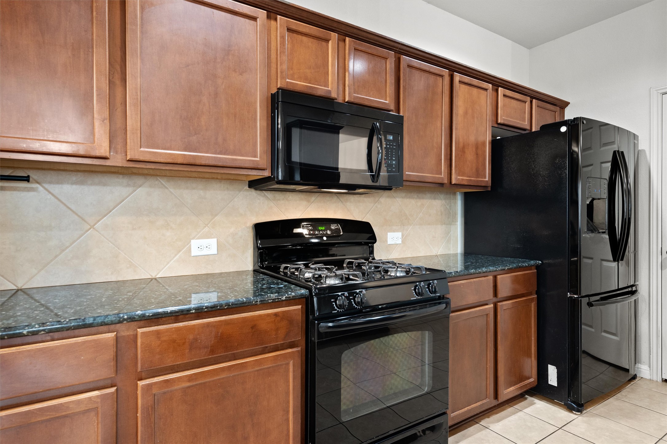 1612 Musket Valley Trail Austin, TX 78754 - Photo 17 of 34 a kitchen with stainless steel appliances granite countertop a refrigerator stove and microwave