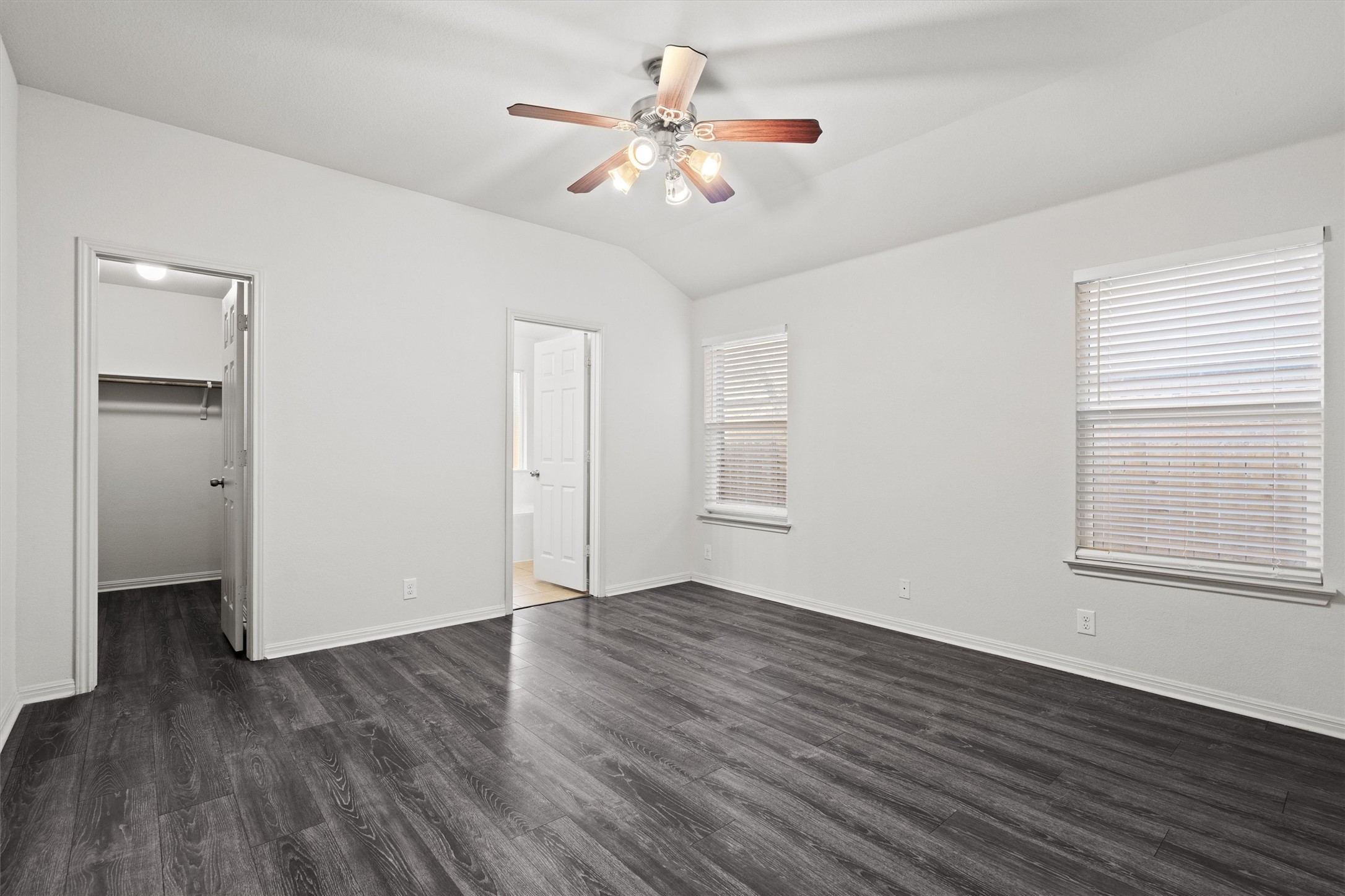 1612 Musket Valley Trail Austin, TX 78754 - Photo 19 of 34 an empty room with wooden floor chandelier fan and windows