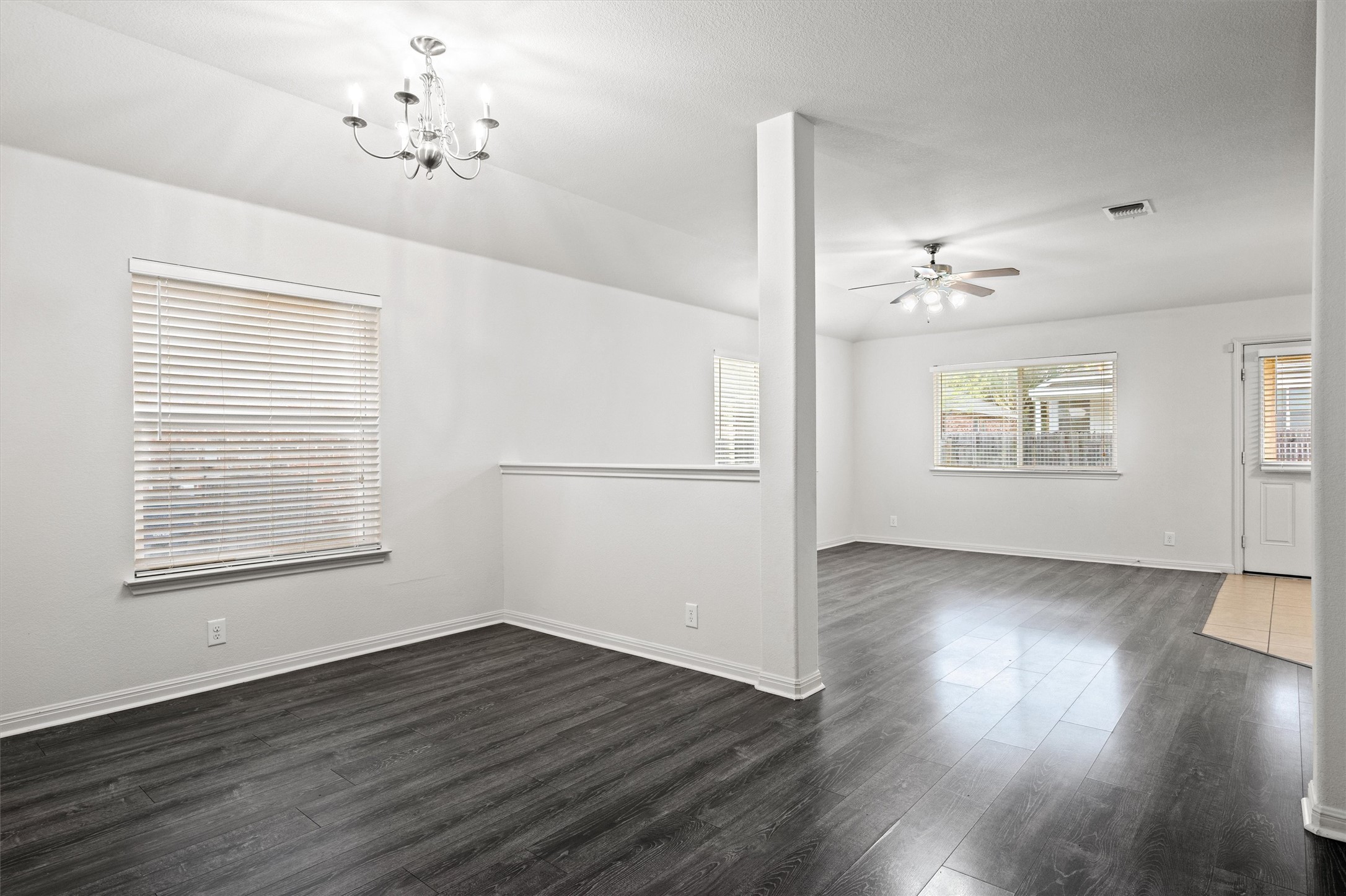 1612 Musket Valley Trail Austin, TX 78754 - Photo 7 of 34 an empty room with wooden floor chandelier and windows