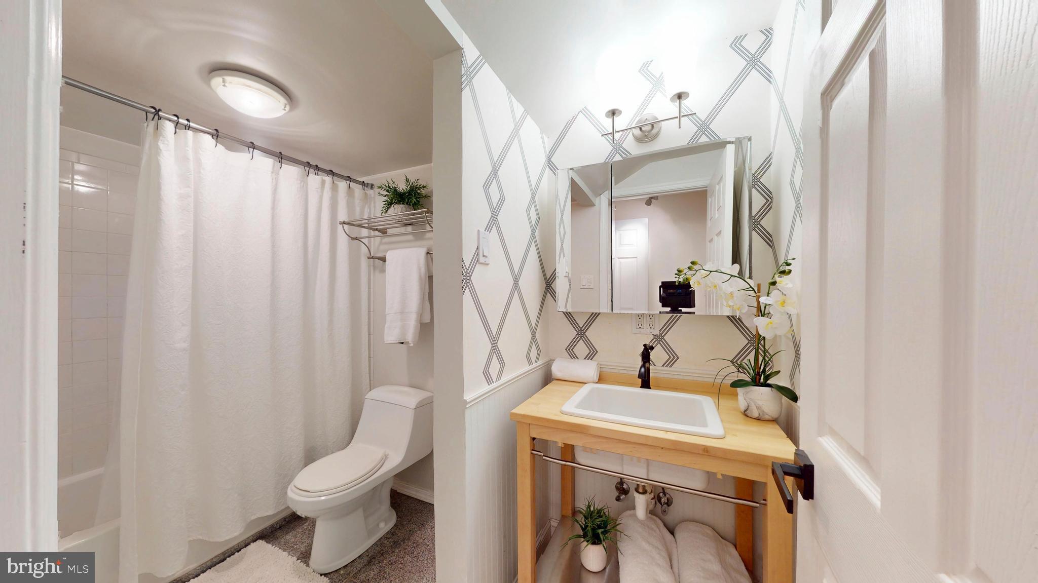 1771 Whisperhill Drive Reston, VA 20194 - Photo 32 of 44 a bathroom with a sink a toilet and shower curtain