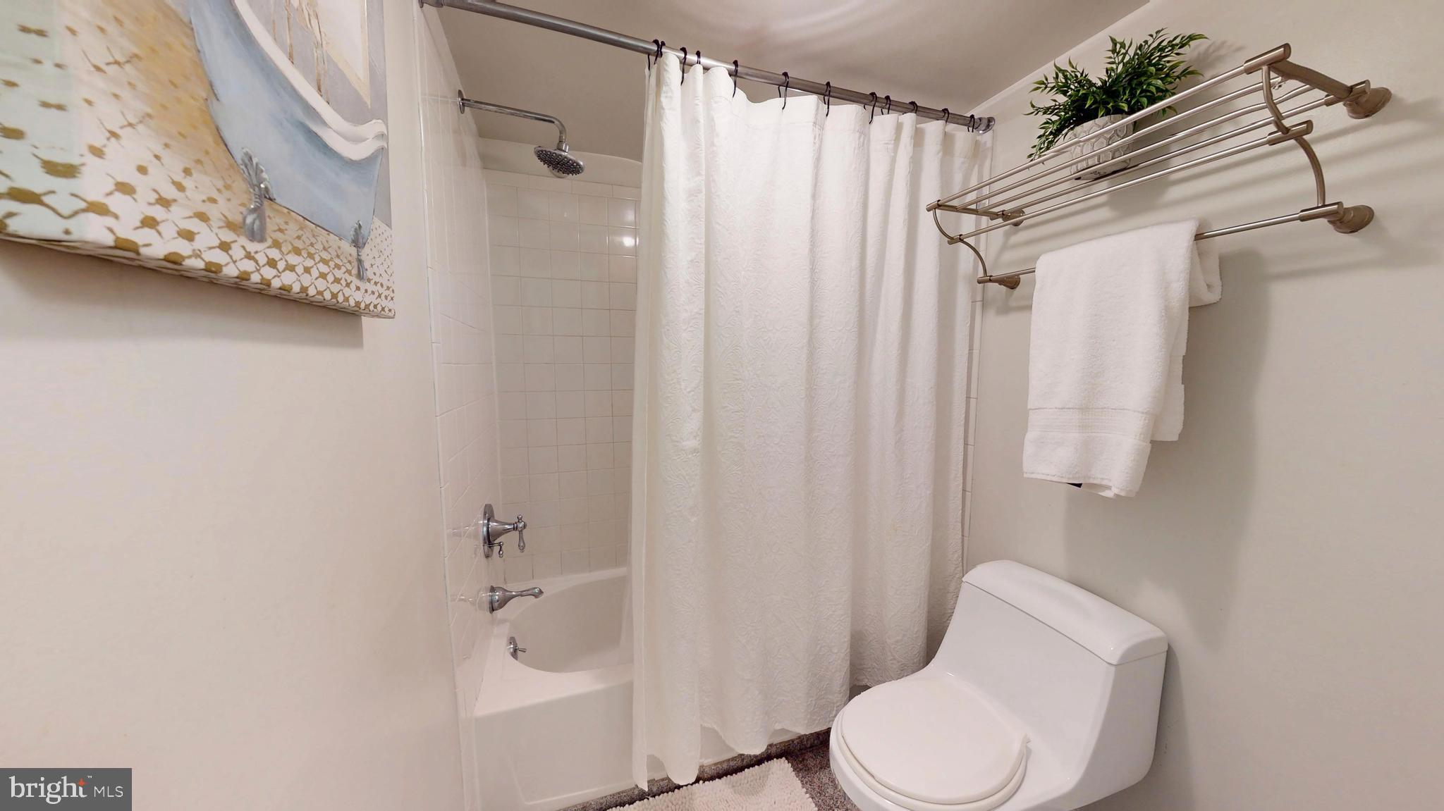 1771 Whisperhill Drive Reston, VA 20194 - Photo 33 of 44 a white toilet sitting next to a shower curtain