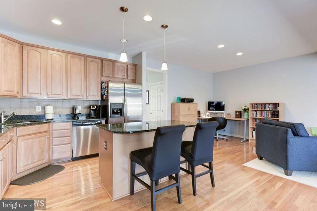 25259 Destination Square Aldie, VA 20105 - Photo 13 of 28 a kitchen with stainless steel appliances kitchen island granite countertop a table and chairs in it