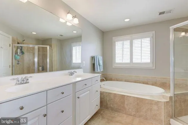 a spacious bathroom with a granite countertop tub sink shower double vanity