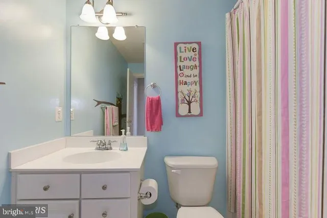 a bathroom with a toilet a sink and a mirror
