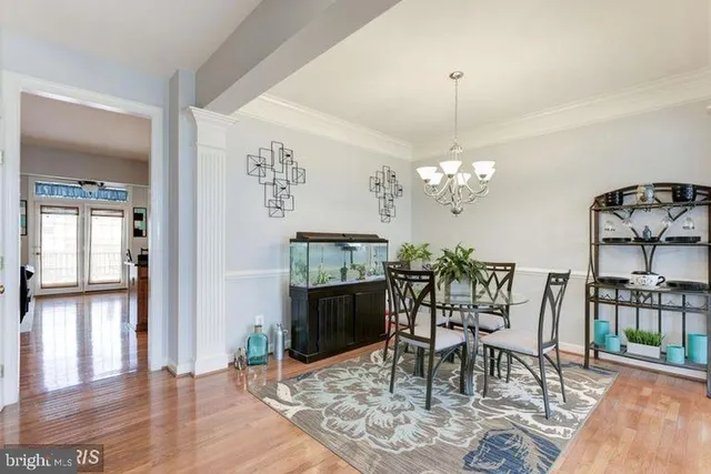 a dining room with furniture a chandelier and wooden floor