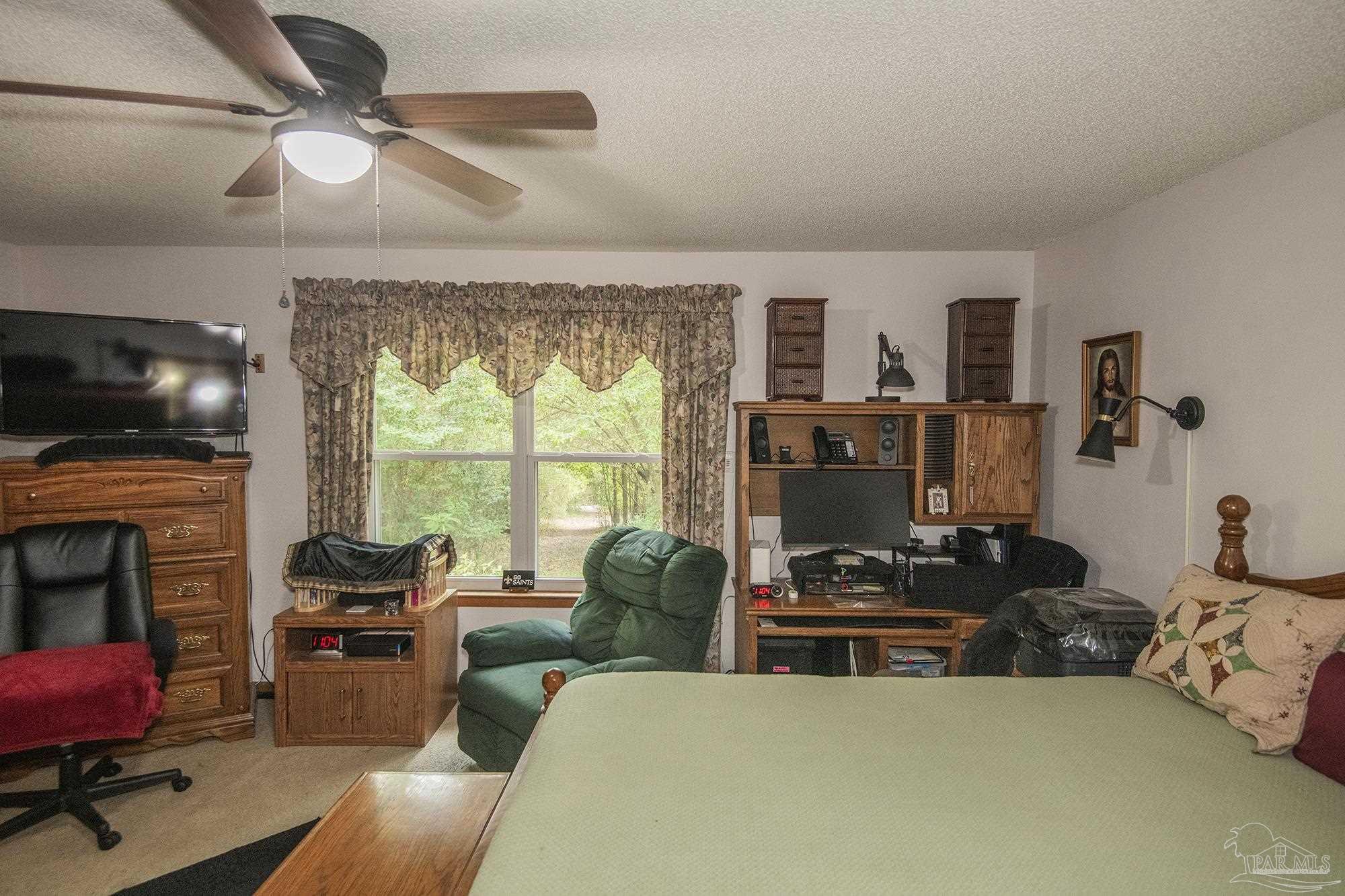 1210 Goldenrod Road Cantonment, FL 32533 - Photo 21 of 50 a living room with furniture a flat screen tv and a fireplace