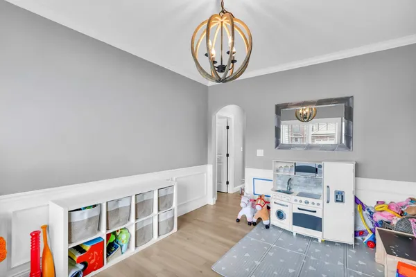 a kitchen with a refrigerator a stove a sink and white cabinets with wooden floor