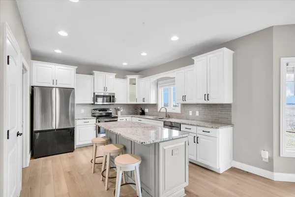 a kitchen with a sink a table and chairs in it