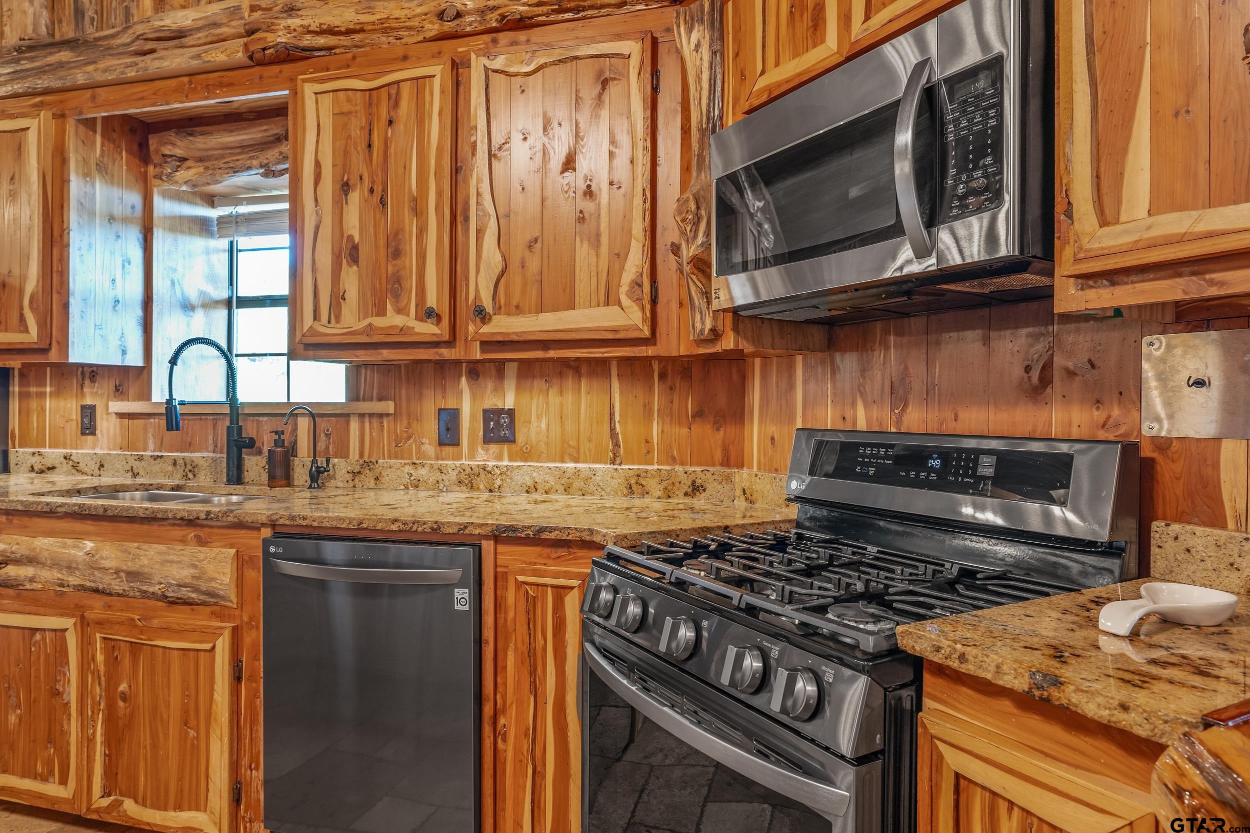 2600 Van Meter Road Kilgore, TX 75662 - Photo 13 of 48 a kitchen with granite countertop a stove top oven cabinetry a sink and dishwasher