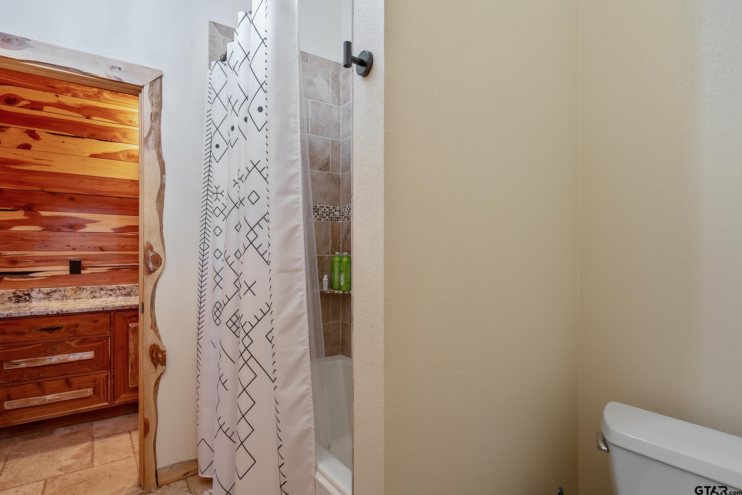 2600 Van Meter Road Kilgore, TX 75662 - Photo 32 of 48 a bathroom with a shower curtain and a toilet