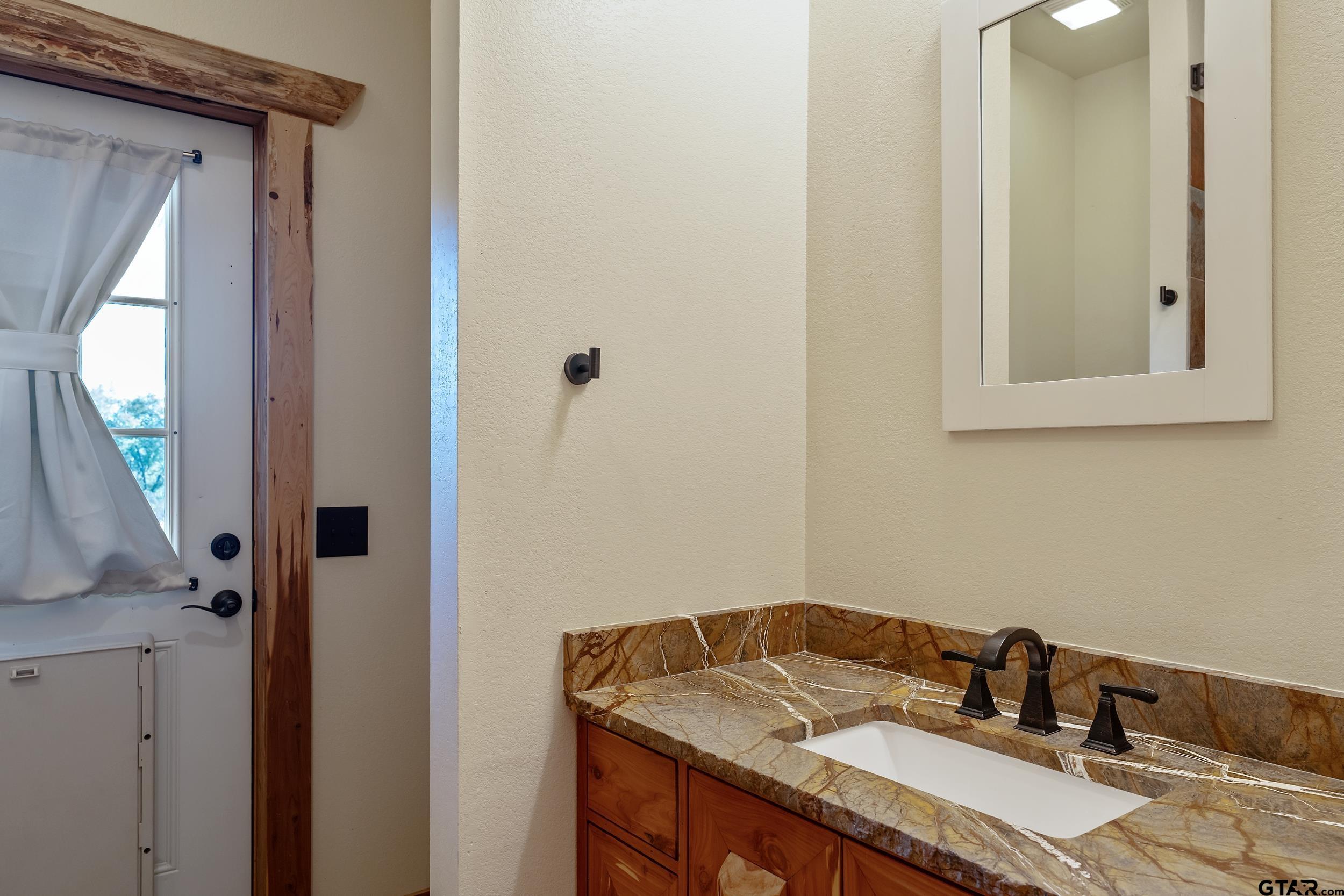 2600 Van Meter Road Kilgore, TX 75662 - Photo 40 of 48 a bathroom with a granite countertop sink and a mirror