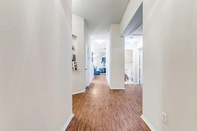 a view of a hallway with wooden floor