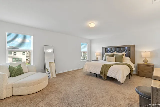 a spacious bedroom with a bed and lamp