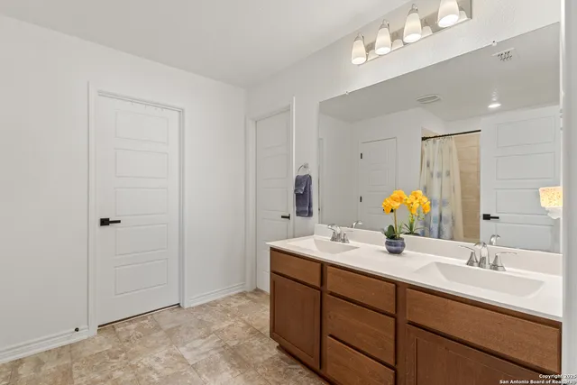 a bathroom with a double vanity sink and a mirror