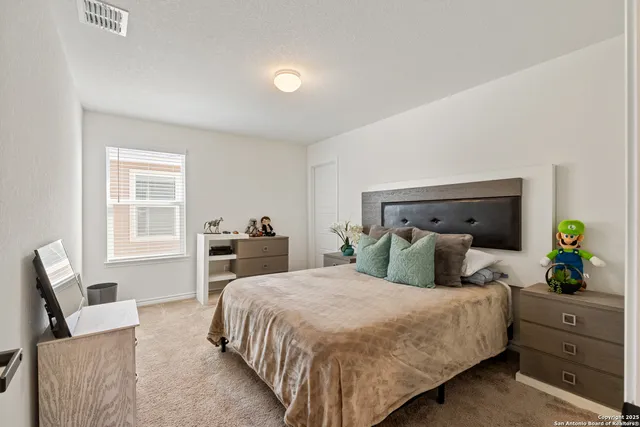 a bedroom with a large bed and windows