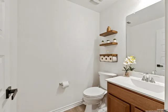 a bathroom with a sink mirror vanity and toilet