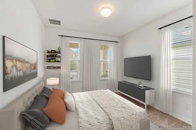 a bedroom with a bed and a flat tv screen on wall