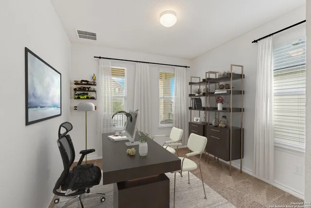 a view of a workspace with furniture and window