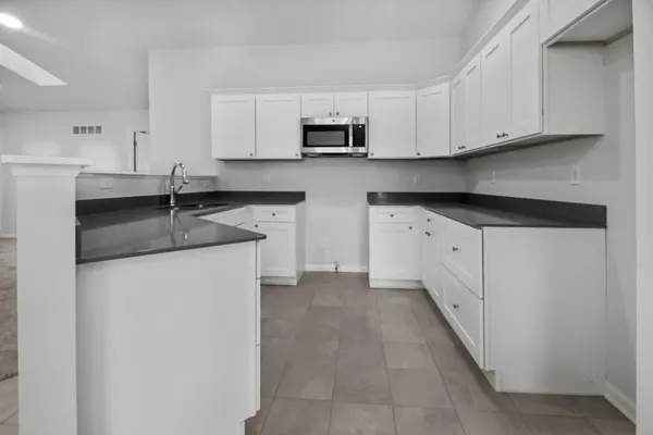 a kitchen with granite countertop white cabinets and a stainless steel appliances
