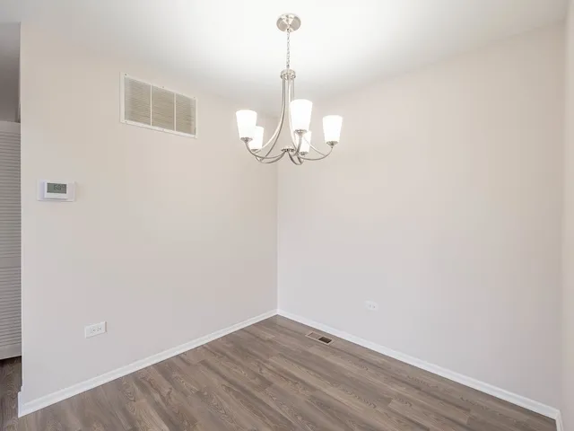 a view of a room with wooden floor and chandelier