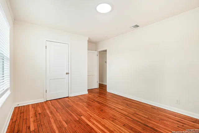 a view of a room with wooden floor and white walls