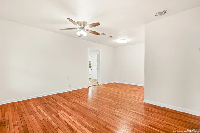 a view of empty room with wooden floor