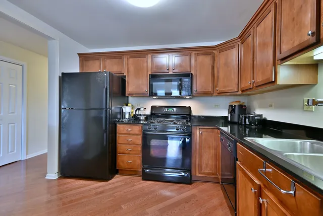 a kitchen with stainless steel appliances granite countertop a refrigerator stove and a sink