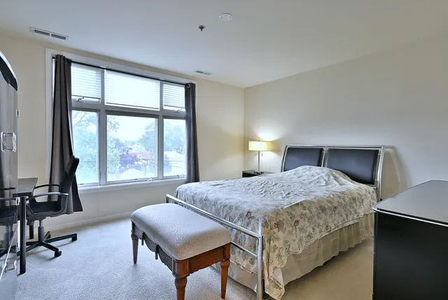 a bedroom with a bed and a large window