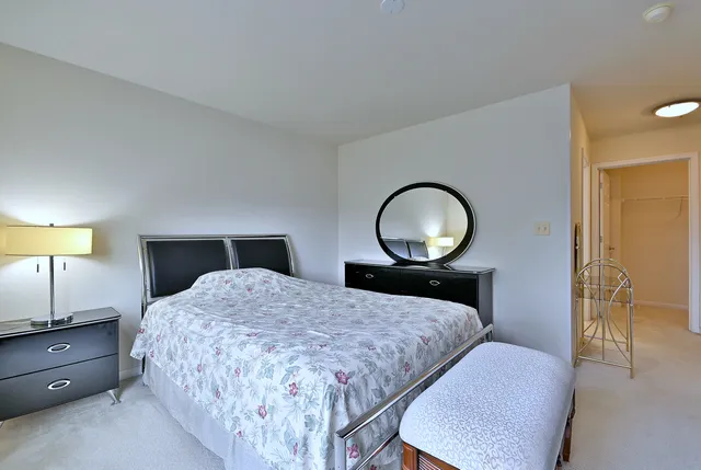 a bedroom with a bed lamps and a mirror