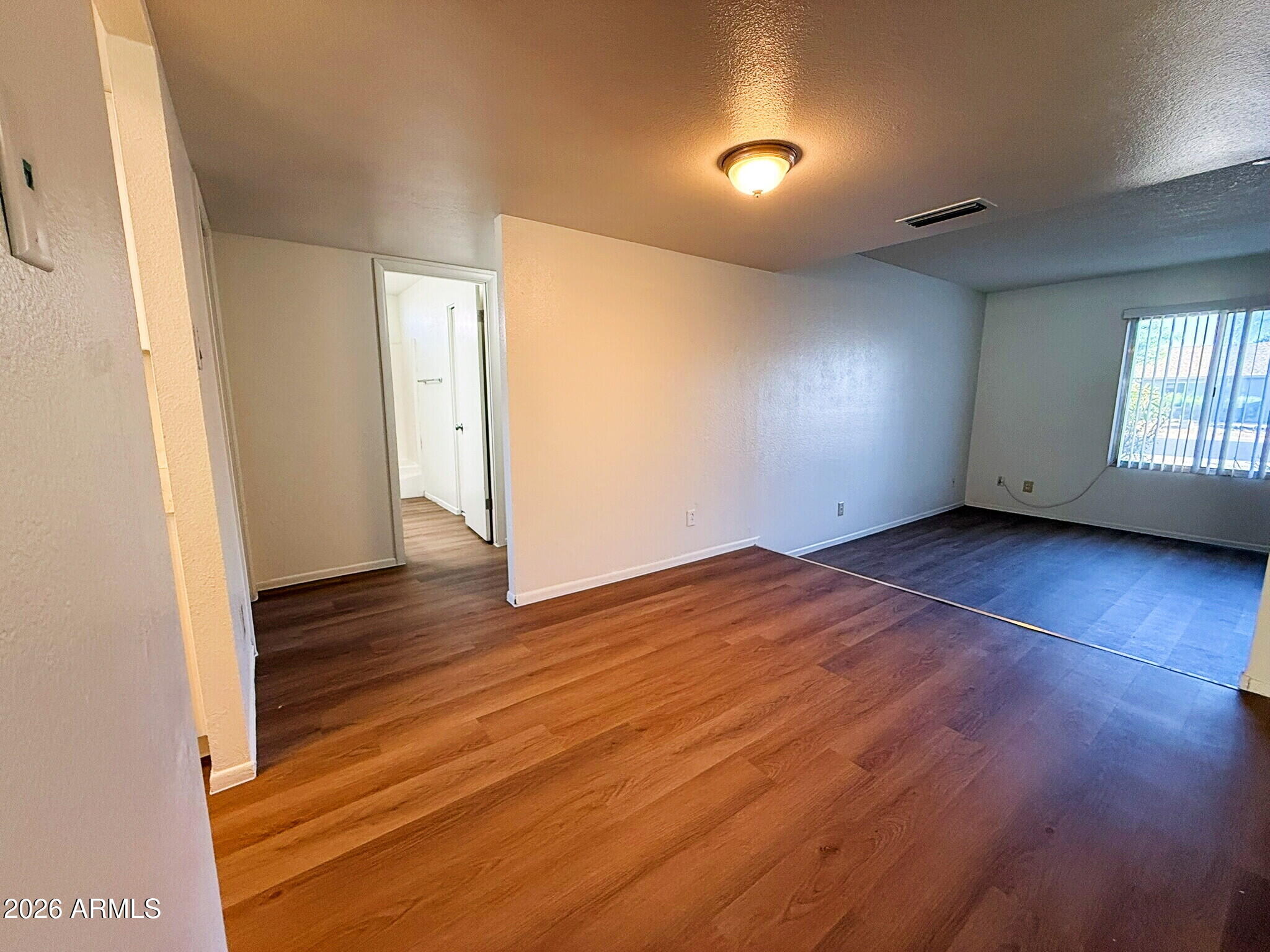 5208 West Calavar Road Glendale, AZ 85306 - Photo 32 of 39 an empty room with wooden floor and windows