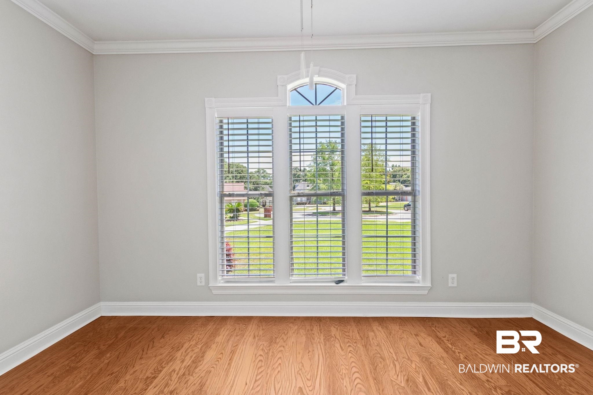 3176 Cedar Court Mobile, AL 36619 - Photo 21 of 33 Triple window unit with transom detail, white louvered blinds, and a bright exterior outlook