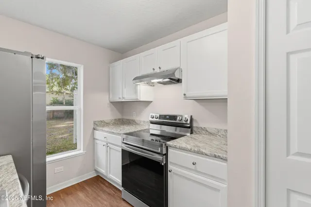 an empty room with windows and ceiling fan